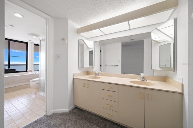 1340 Gulf Blvd Unit 12A, Clearwater Beach, FL 33767 - bathroom with double vanity, tile patterned floors, a bath, a textured ceiling, and recessed lighting