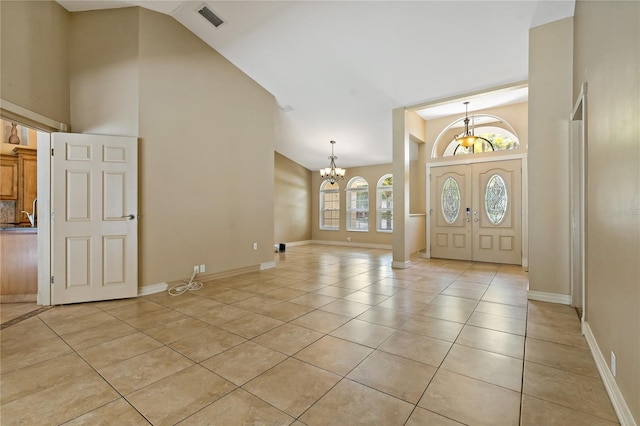 1046 Middlesex Dr, New Port Richey, FL 34655 - entryway featuring high vaulted ceiling, light tile patterned floors, and a chandelier