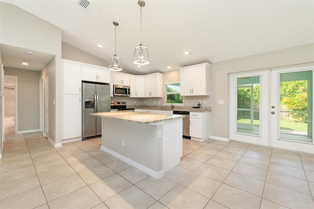 13116 Marathon Blvd, Port Charlotte, FL 33981 - kitchen featuring appliances with stainless steel finishes, lofted ceiling, a kitchen island, white cabinetry, and light tile patterned floors