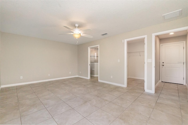 13116 Marathon Blvd, Port Charlotte, FL 33981 - unfurnished bedroom featuring a spacious closet, light tile patterned flooring, a closet, and ceiling fan