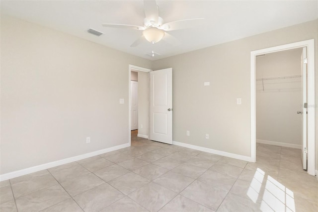 13116 Marathon Blvd, Port Charlotte, FL 33981 - unfurnished bedroom with a spacious closet, a closet, ceiling fan, and light tile patterned flooring