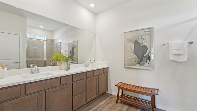 7803 Wheat Stone Dr, Zephyrhills, FL 33540 - full bath with double vanity, a shower stall, wood finished floors, and recessed lighting