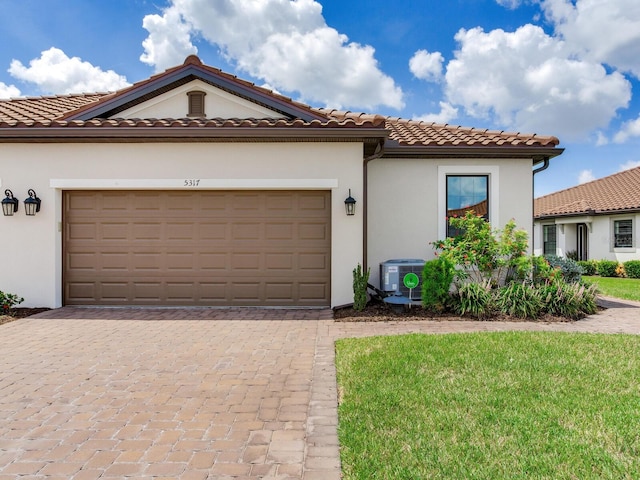 5317 Rushmere Ct, Palmetto, FL 34221 - mediterranean / spanish home with decorative driveway, stucco siding, a garage, and a tiled roof