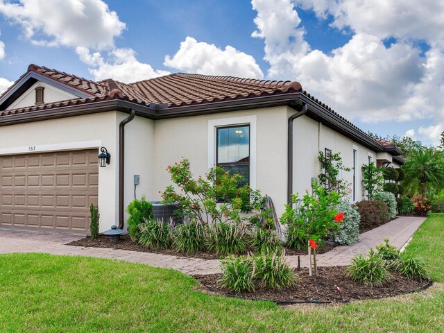 5317 Rushmere Ct, Palmetto, FL 34221 - view of front of house with stucco siding, an attached garage, a tile roof, and a front yard