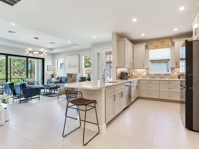 5317 Rushmere Ct, Palmetto, FL 34221 - kitchen with a peninsula, a chandelier, stainless steel dishwasher, tasteful backsplash, and open floor plan