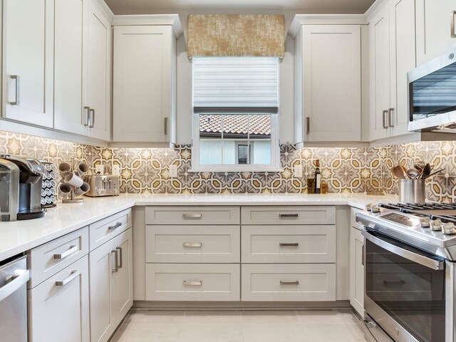 5317 Rushmere Ct, Palmetto, FL 34221 - kitchen with stainless steel appliances, light countertops, tasteful backsplash, white cabinets, and light tile patterned flooring