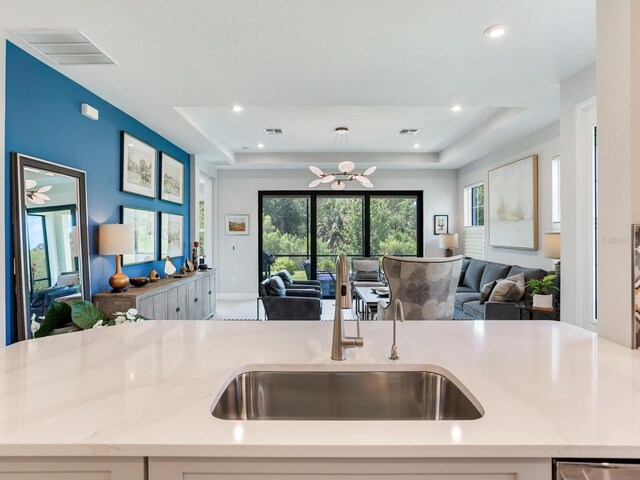 5317 Rushmere Ct, Palmetto, FL 34221 - kitchen featuring open floor plan, light stone countertops, a chandelier, a raised ceiling, and recessed lighting
