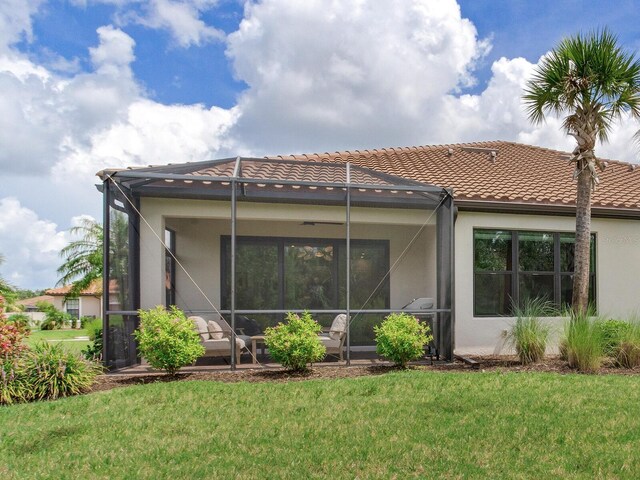 5317 Rushmere Ct, Palmetto, FL 34221 - back of house featuring stucco siding, glass enclosure, a lawn, and a patio