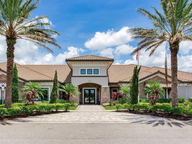 5317 Rushmere Ct, Palmetto, FL 34221 - mediterranean / spanish-style home with french doors, stucco siding, stone siding, and a tile roof