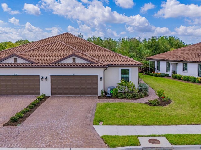 5317 Rushmere Ct, Palmetto, FL 34221 - mediterranean / spanish-style home with stucco siding, a front yard, a tiled roof, driveway, and a garage