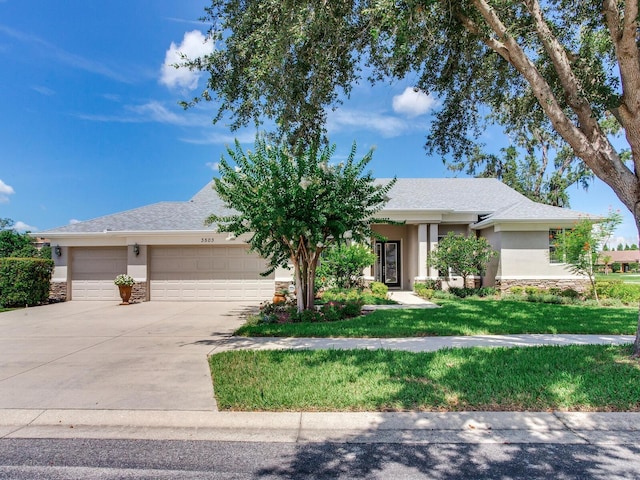 3503 Graycliff Ln, Brandon, FL 33511 - view of front facade with stone siding, a garage, driveway, stucco siding, and a front yard