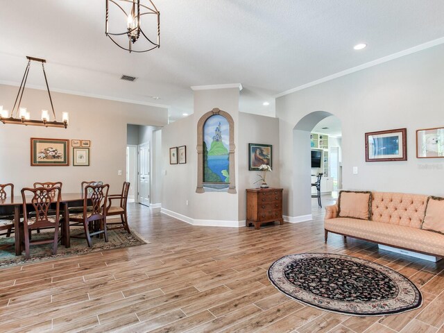 3503 Graycliff Ln, Brandon, FL 33511 - living area with a chandelier, arched walkways, light wood-style floors, crown molding, and recessed lighting