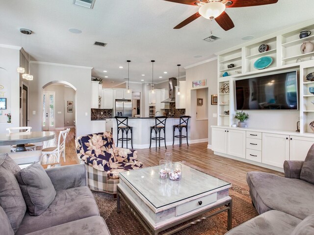 3503 Graycliff Ln, Brandon, FL 33511 - living area with ceiling fan, ornamental molding, arched walkways, light wood-style flooring, and recessed lighting