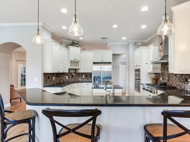 3503 Graycliff Ln, Brandon, FL 33511 - kitchen with appliances with stainless steel finishes, arched walkways, crown molding, a peninsula, and recessed lighting