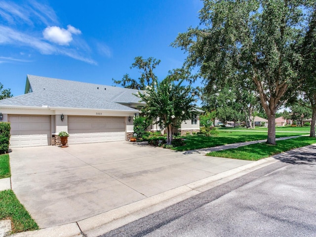 3503 Graycliff Ln, Brandon, FL 33511 - view of front of house with a garage, concrete driveway, stone siding, a front lawn, and stucco siding