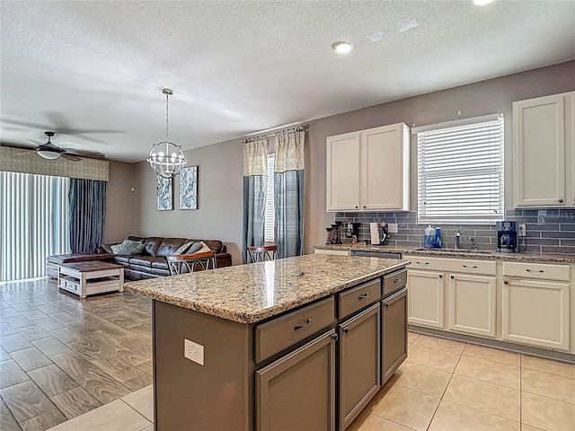 18339 Fish Loop, Land O Lakes, FL 34638 - kitchen featuring plenty of natural light, open floor plan, backsplash, light stone counters, and a textured ceiling