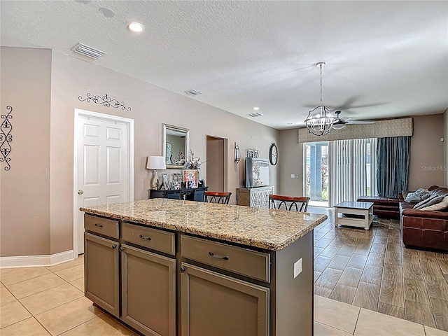 18339 Fish Loop, Land O Lakes, FL 34638 - kitchen with open floor plan, a chandelier, a kitchen island, hanging light fixtures, and light stone counters