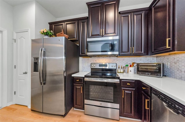2119 Broadway View Ave, Brandon, FL 33510 - kitchen with appliances with stainless steel finishes, light countertops, backsplash, light wood-style floors, and dark brown cabinets