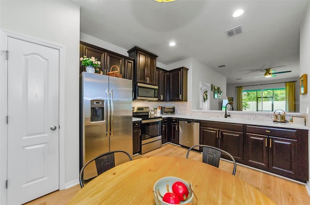 2119 Broadway View Ave, Brandon, FL 33510 - kitchen featuring appliances with stainless steel finishes, dark brown cabinets, light wood-style flooring, light countertops, and recessed lighting