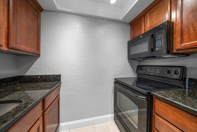 720 Lyndhurst St Unit 1101, Dunedin, FL 34698 - kitchen featuring black appliances, a textured wall, dark stone counters, and brown cabinetry