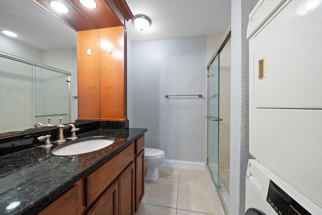 720 Lyndhurst St Unit 1101, Dunedin, FL 34698 - bathroom with a stall shower, stacked washing machine and dryer, vanity, and tile patterned flooring