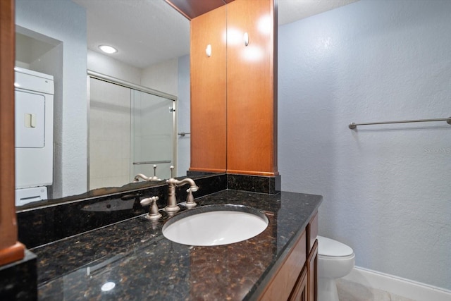 720 Lyndhurst St Unit 1101, Dunedin, FL 34698 - full bathroom featuring stacked washer / dryer, vanity, a shower with door, and a textured wall