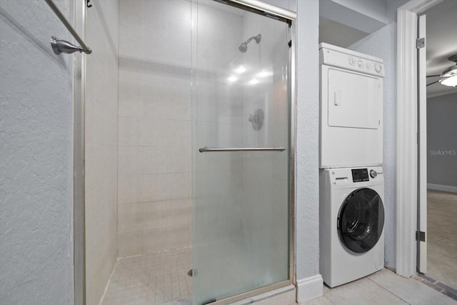 720 Lyndhurst St Unit 1101, Dunedin, FL 34698 - bathroom featuring stacked washer / dryer, a stall shower, a textured wall, and tile patterned floors