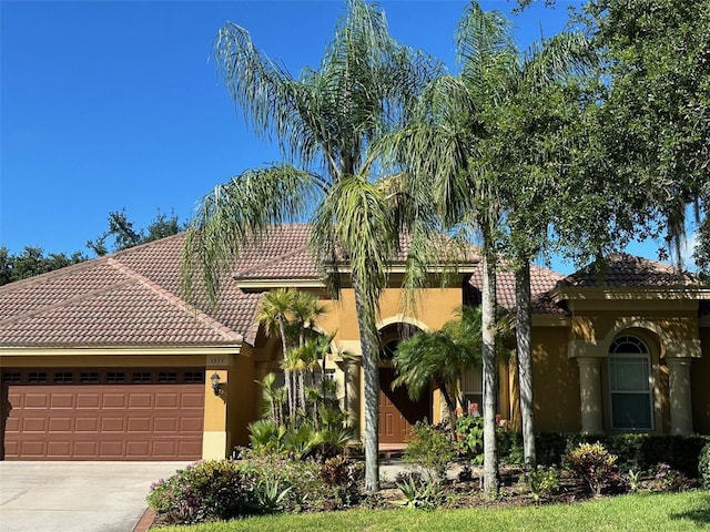 1353 El Pardo Dr, Trinity, FL 34655 - mediterranean / spanish-style home featuring a tiled roof, a garage, stucco siding, and concrete driveway