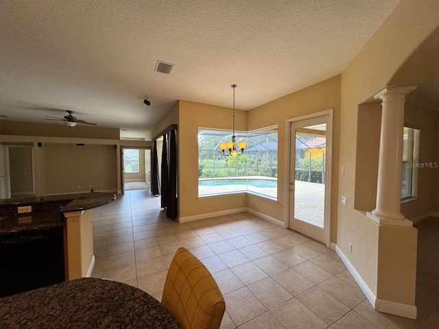1353 El Pardo Dr, Trinity, FL 34655 - unfurnished dining area with ornate columns, plenty of natural light, light tile patterned floors, and a textured ceiling