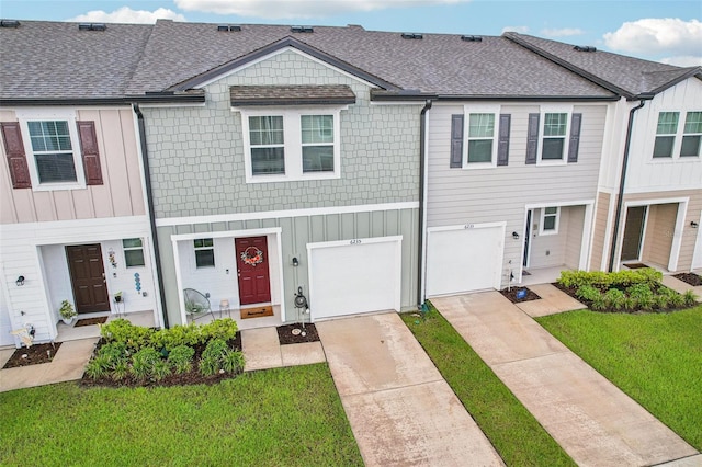 6235 Bucket Ct, Gibsonton, FL 33534 - multi unit property with driveway, a shingled roof, a garage, a front lawn, and board and batten siding