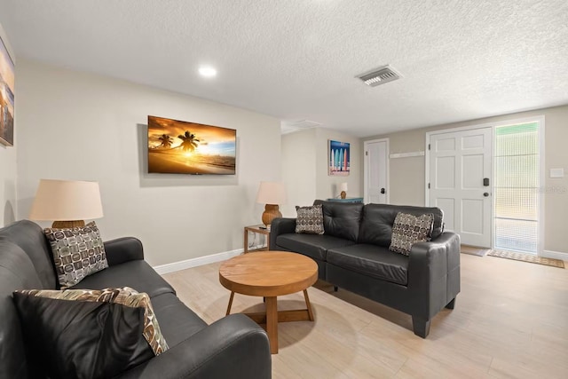 201 S St, Palm Harbor, FL 34683 - living area featuring light wood-style floors, a textured ceiling, and recessed lighting