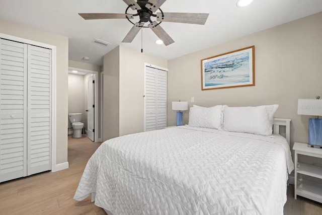 201 S St, Palm Harbor, FL 34683 - bedroom featuring multiple closets, light wood-style flooring, recessed lighting, ensuite bath, and a ceiling fan