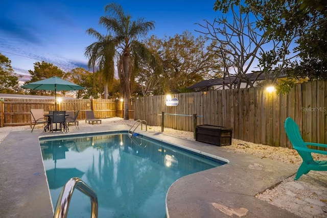 201 S St, Palm Harbor, FL 34683 - pool at dusk with a patio and a fenced backyard