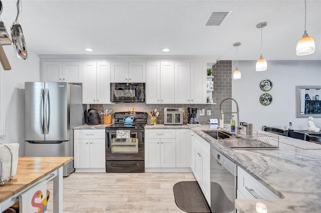900 Maclaren Dr N Unit D, Palm Harbor, FL 34684 - kitchen with black appliances, open shelves, decorative backsplash, light wood finished floors, and light stone countertops