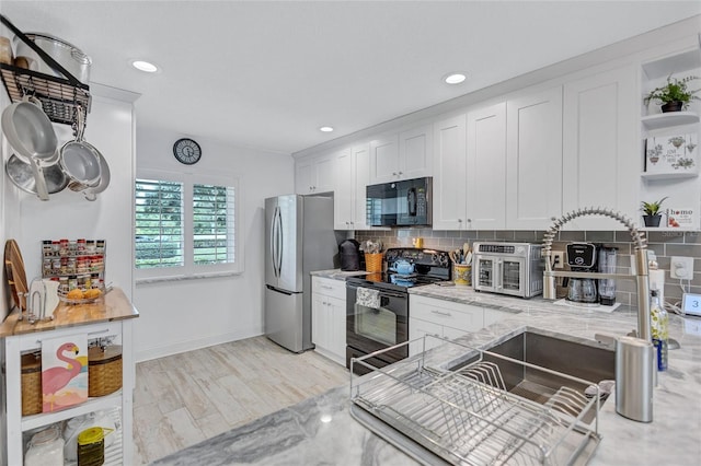 900 Maclaren Dr N Unit D, Palm Harbor, FL 34684 - kitchen with black appliances, white cabinets, open shelves, tasteful backsplash, and recessed lighting