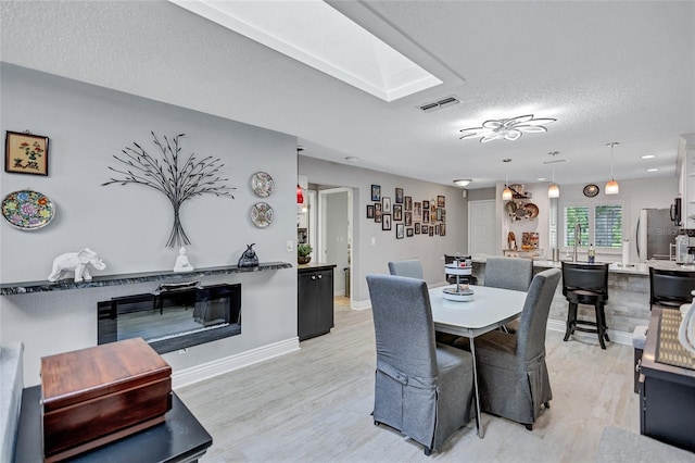 900 Maclaren Dr N Unit D, Palm Harbor, FL 34684 - dining space with light wood-style floors and a textured ceiling