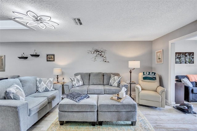 900 Maclaren Dr N Unit D, Palm Harbor, FL 34684 - living room featuring light wood finished floors, a textured ceiling, and ceiling fan