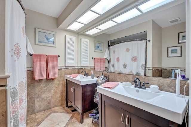 900 Maclaren Dr N Unit D, Palm Harbor, FL 34684 - bathroom featuring vanity, tile walls, and a wainscoted wall