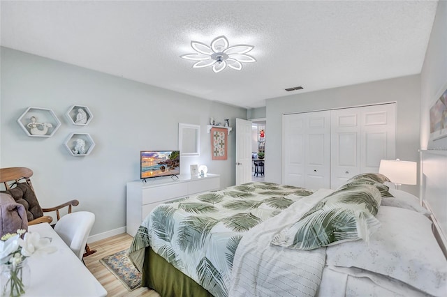 900 Maclaren Dr N Unit D, Palm Harbor, FL 34684 - bedroom with light wood finished floors, a closet, and a textured ceiling