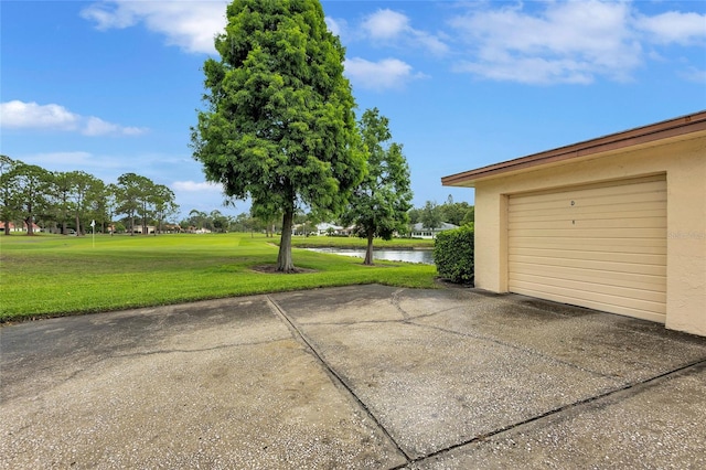 900 Maclaren Dr N Unit D, Palm Harbor, FL 34684 - garage with a water view, concrete driveway, and golf course view
