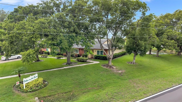 900 Maclaren Dr N Unit D, Palm Harbor, FL 34684 - view of property hidden behind natural elements featuring a front yard
