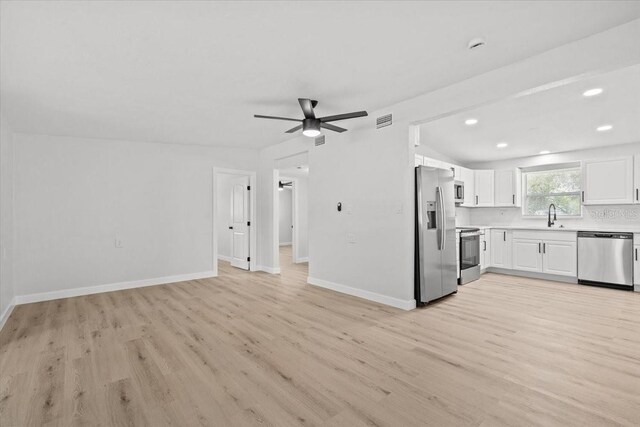 2701 Camellia Ter, Punta Gorda, FL 33950 - kitchen with stainless steel appliances, light countertops, light wood-style floors, open floor plan, and white cabinets