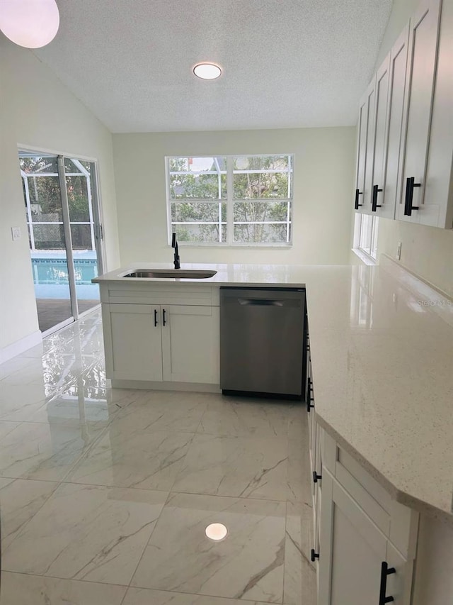 10444 Fordham St, Spring Hill, FL 34608 - kitchen with dishwasher, a textured ceiling, light marble finish flooring, light stone countertops, and white cabinets