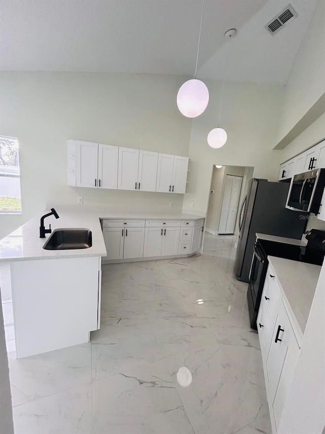 10444 Fordham St, Spring Hill, FL 34608 - kitchen featuring black electric range oven, a towering ceiling, stainless steel microwave, white cabinets, and light marble finish floors