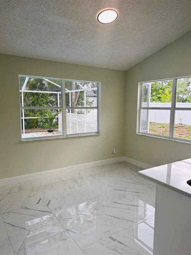 10444 Fordham St, Spring Hill, FL 34608 - empty room featuring healthy amount of natural light, marble finish floors, and a textured ceiling