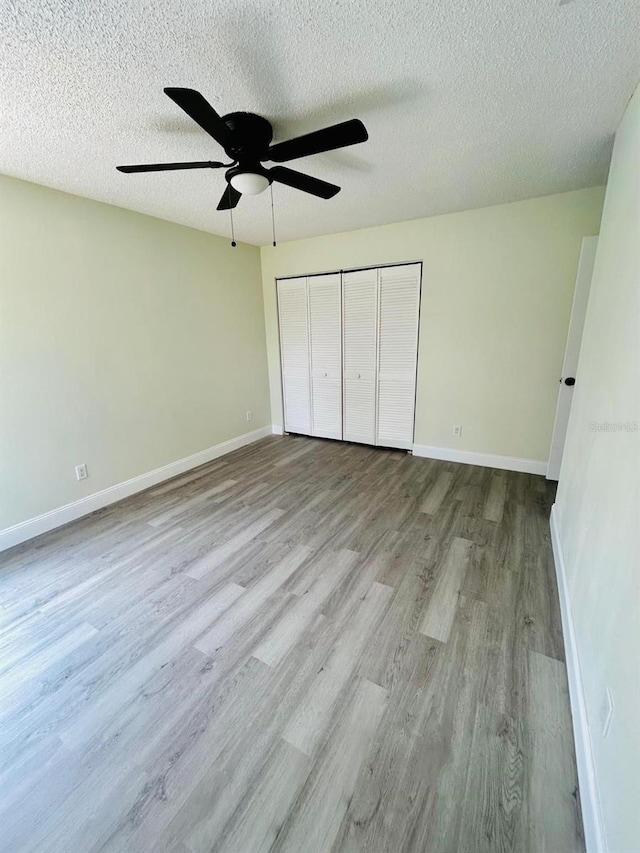 10444 Fordham St, Spring Hill, FL 34608 - unfurnished bedroom with wood finished floors, a closet, a textured ceiling, and ceiling fan