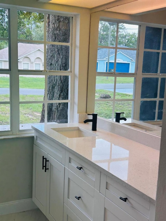 10444 Fordham St, Spring Hill, FL 34608 - kitchen featuring light stone counters, healthy amount of natural light, and white cabinets
