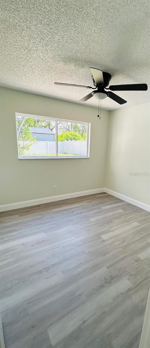 10444 Fordham St, Spring Hill, FL 34608 - spare room with a textured ceiling, wood finished floors, and ceiling fan