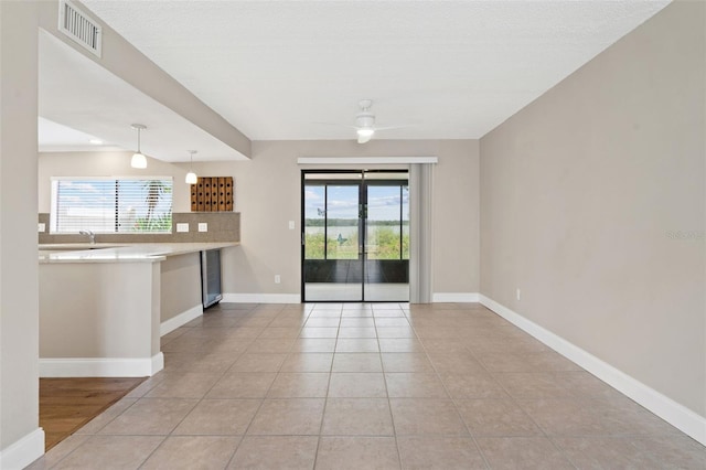 9209 Seminole Blvd Unit 13, Seminole, FL 33772 - unfurnished living room with beverage cooler, plenty of natural light, a ceiling fan, and light tile patterned flooring