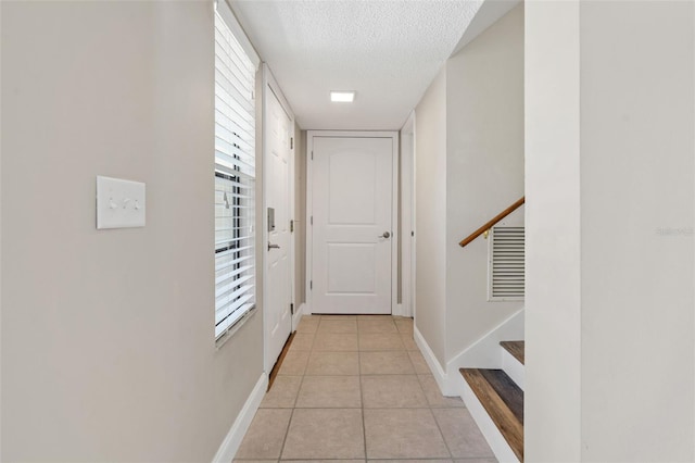 9209 Seminole Blvd Unit 13, Seminole, FL 33772 - hallway with a textured ceiling, light tile patterned flooring, stairs, and plenty of natural light
